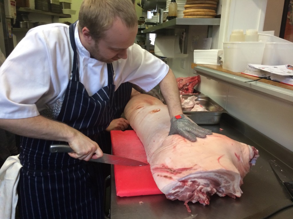 Tomasz Wolak, a Polish chef working at L'Escargo Bleu in Edinburgh butchering a whole pig for the restaurant.